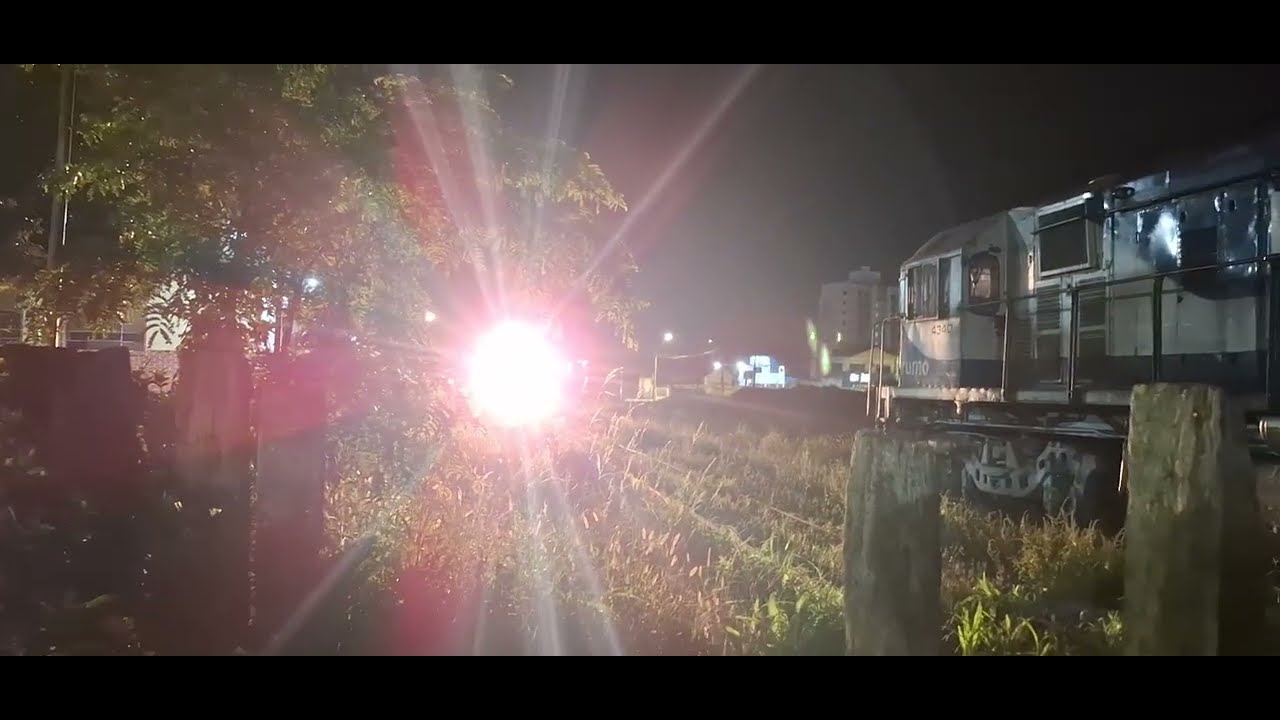 Luz forte e velocidade alta no trecho, vazio noturno na estação ferroviária de Joinville LJL 