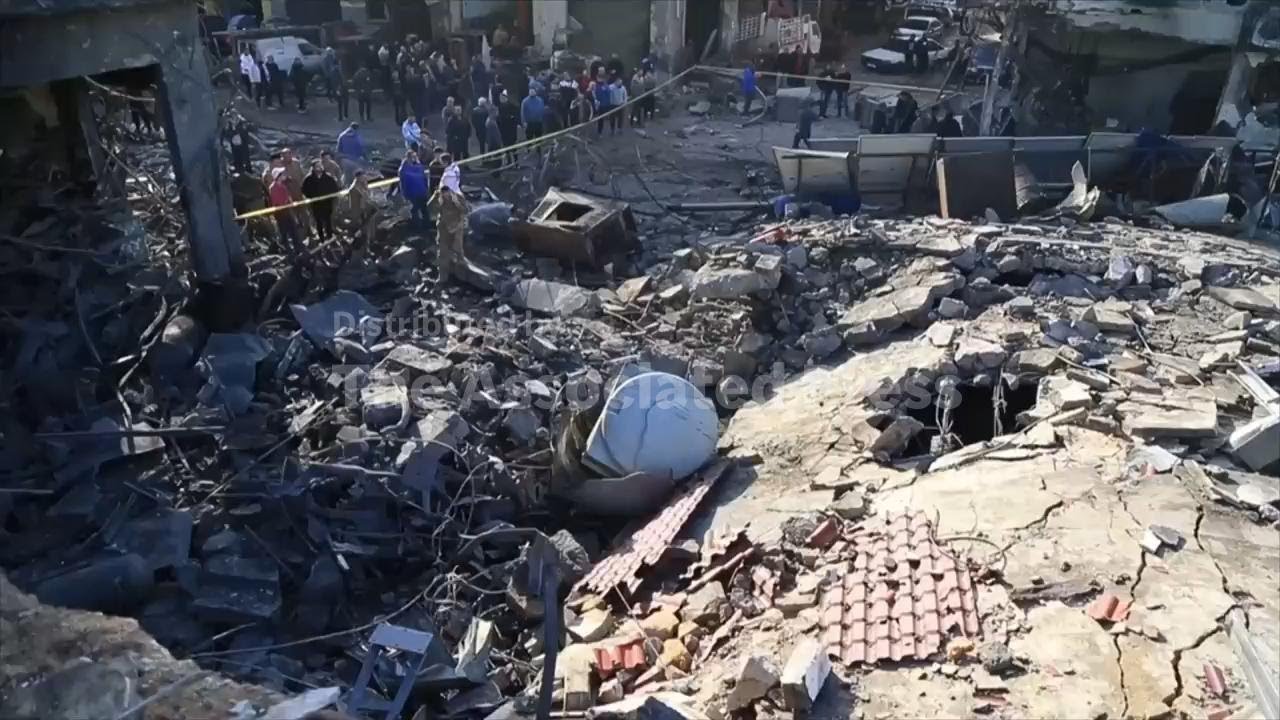 Residents of Sidon assess the damage after an Israeli strike levels commercial building