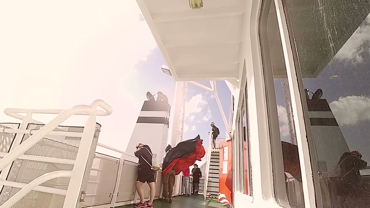 At the front of the ferry with a wide women's raincoat ...