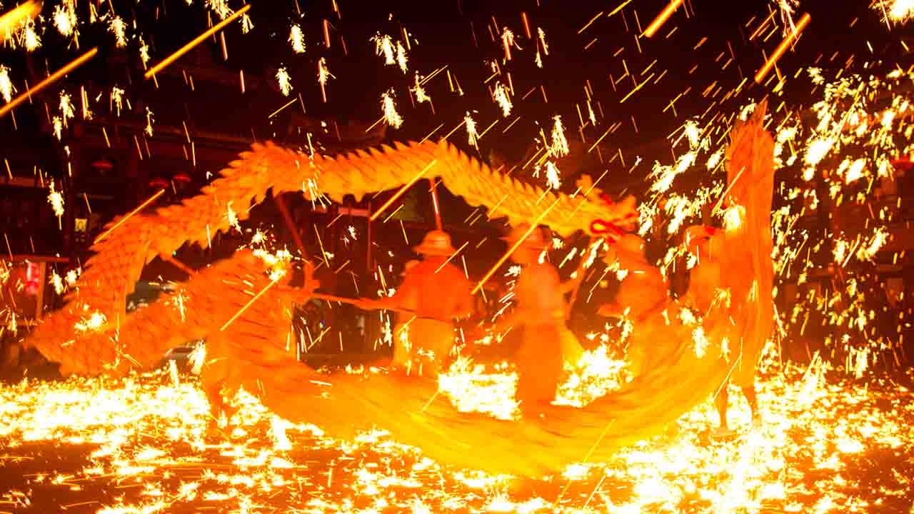 Spring Festival celebration sees performers blasted with firework sparks for a new year blessing