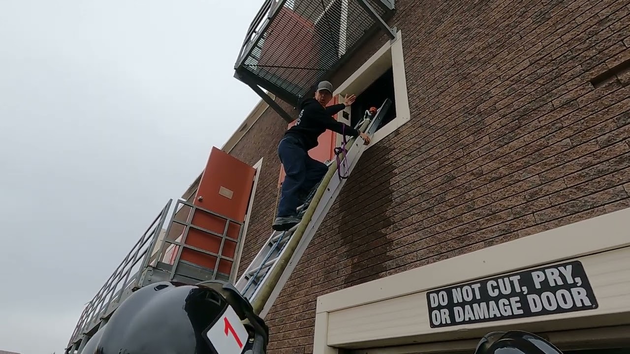 Taking a charged hose up a ladder