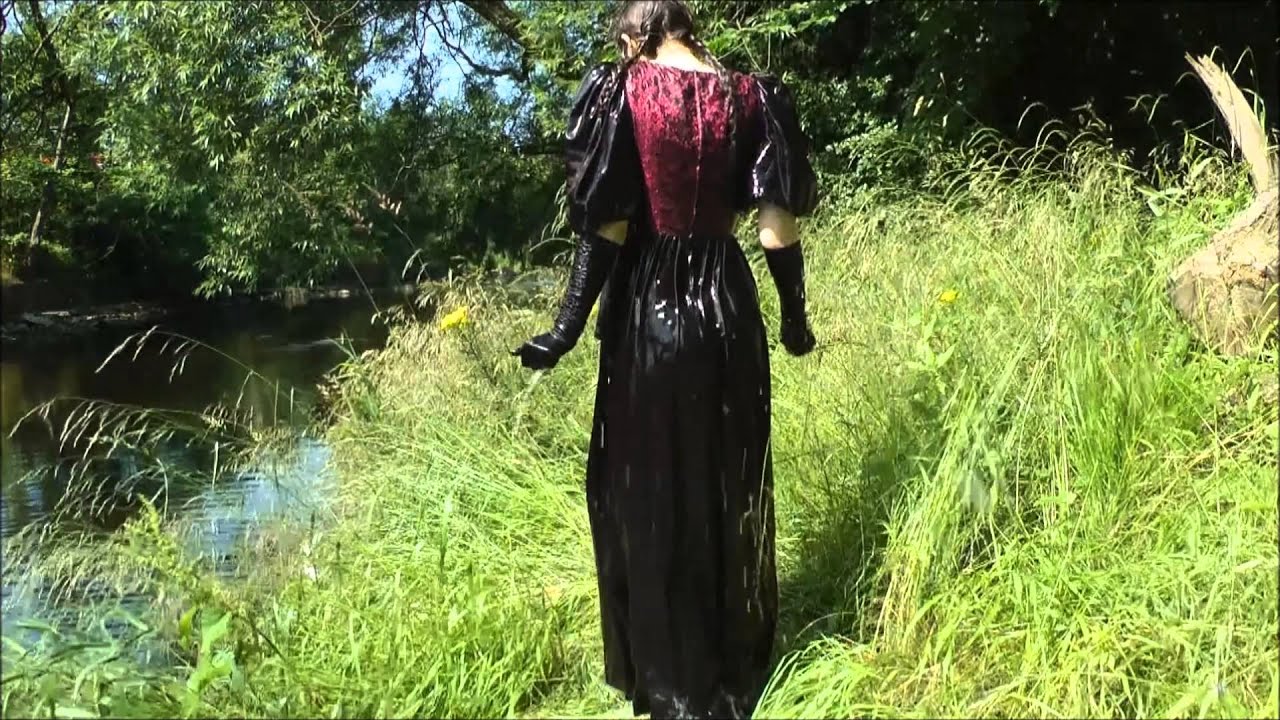 Girl in formal dress takes buckets of water then into the river in her dress