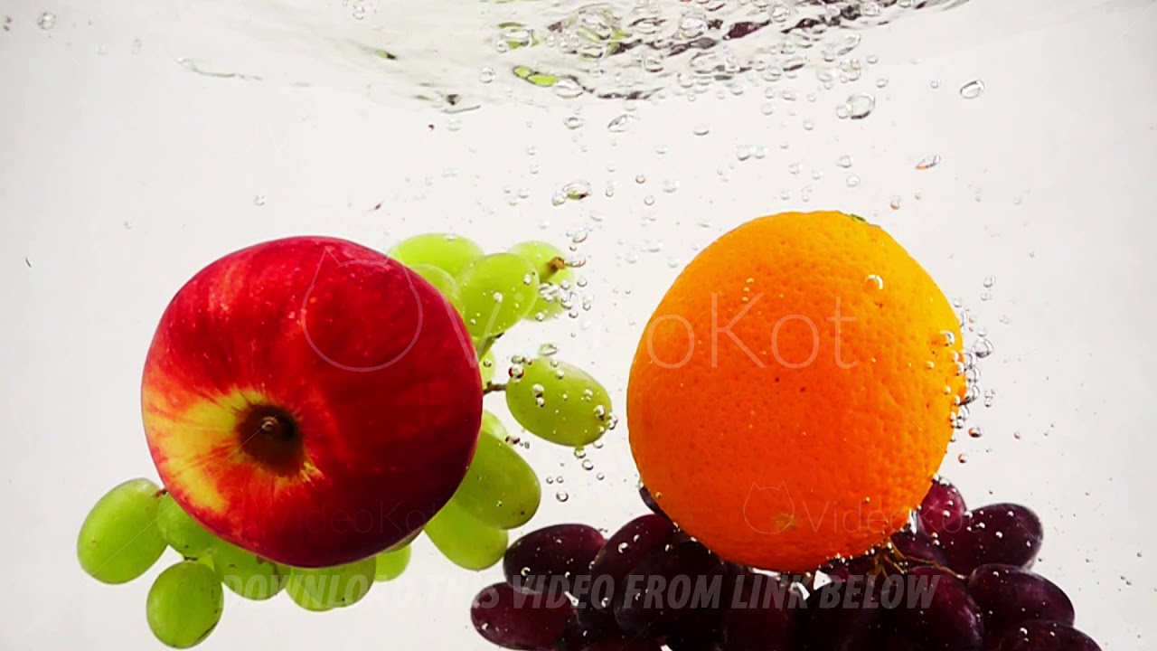 The orange, apple and grapes falling in water with bubbles. Video in slow motion. Fruits on isolated