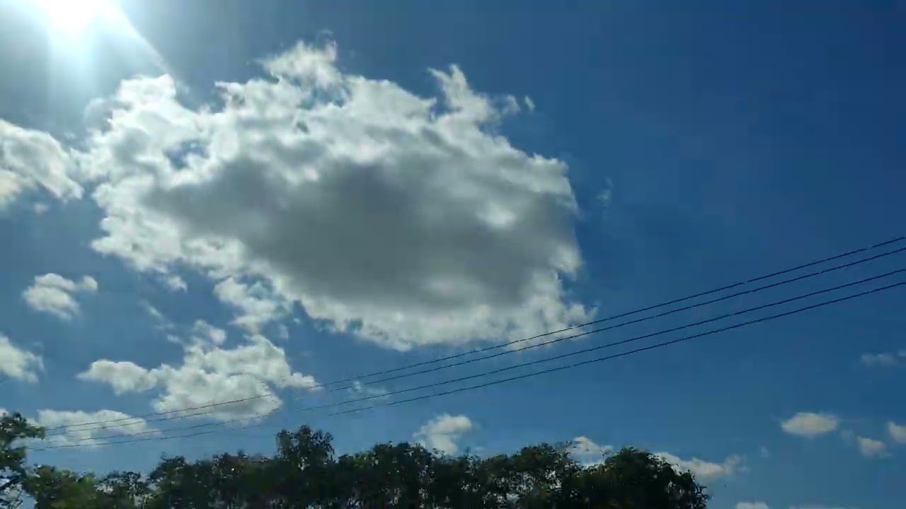 The sky is clear and vast, with white clouds like cotton candy.