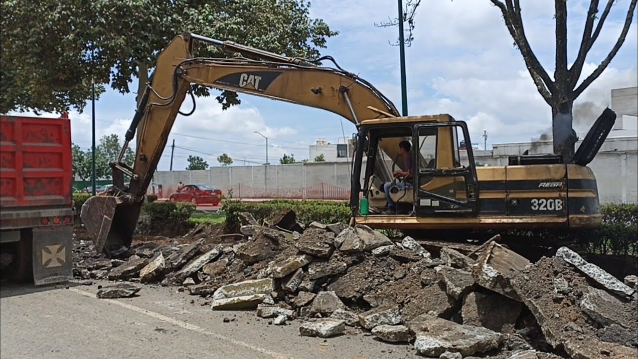 Caterpillar 320B Excavator loading dump trucks