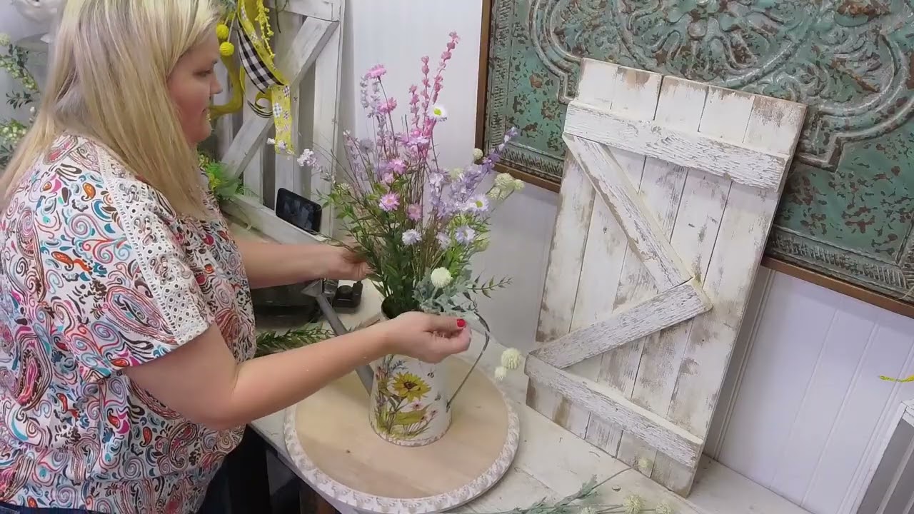 Цветочная композиция из лейки с лавандой и розовыми цветами.