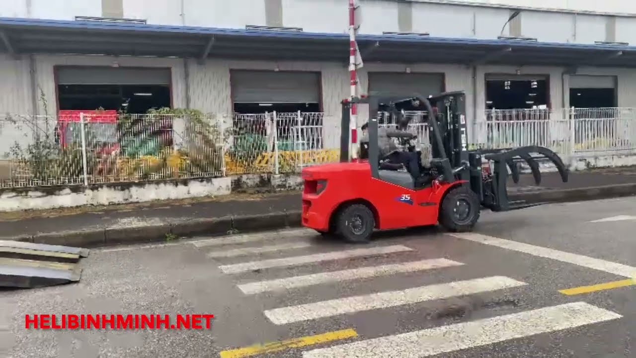 Xe nâng kẹp gỗ, xe nâng Heli lắp kẹp gỗ bàn giao cho quý khách hàng chuyển gỗ viên nén.