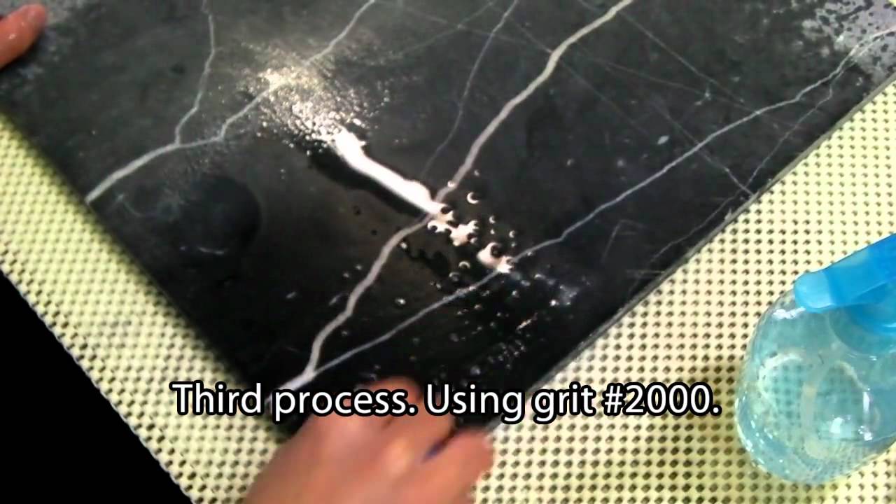 Black marble tile cleaning by hand pads