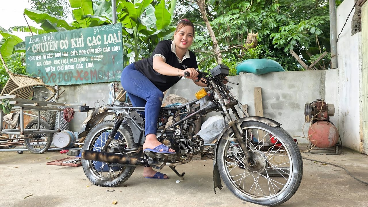 The girl repaired and restored the old Honda Win 100 motorbike for the neighbor.