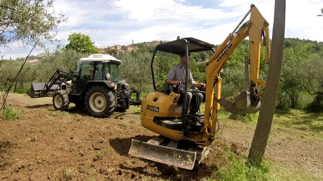 Miniescavatore komatsu e trattore lamborghini con trincia  al lavoro