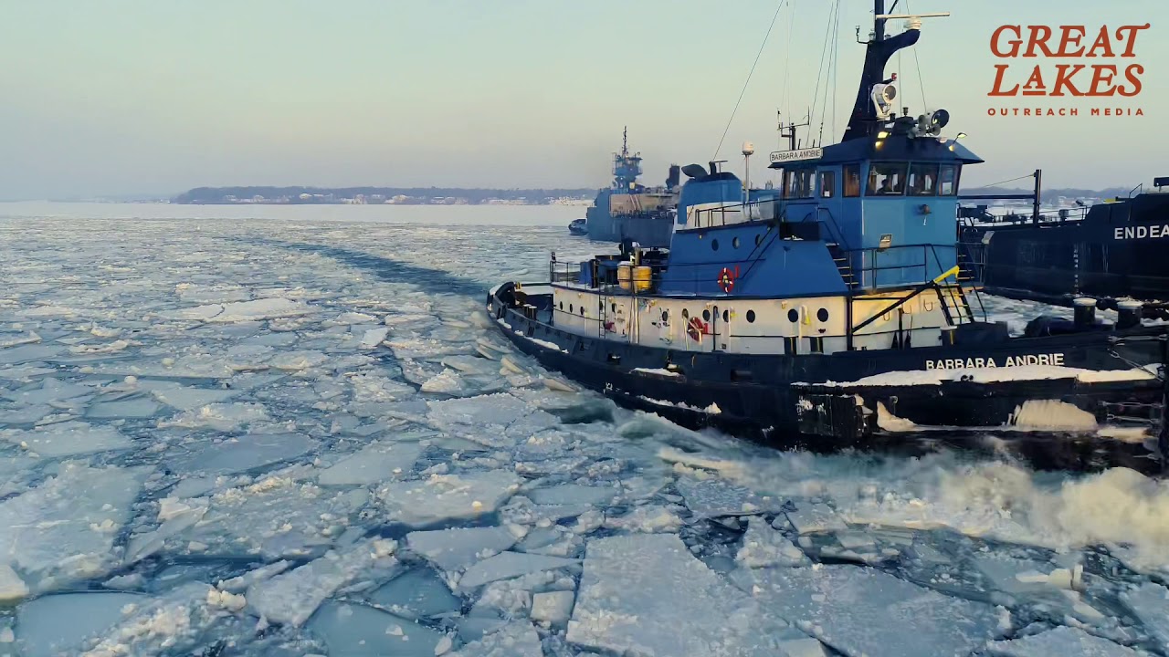 Tugboat Breaking Ice for Barge Caught in Ice