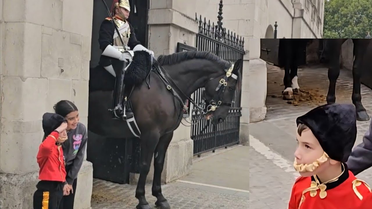 A YOUNG BOY DRESSED LIKE A KING'S GUARD SALUTES TO THE HORE GUARD