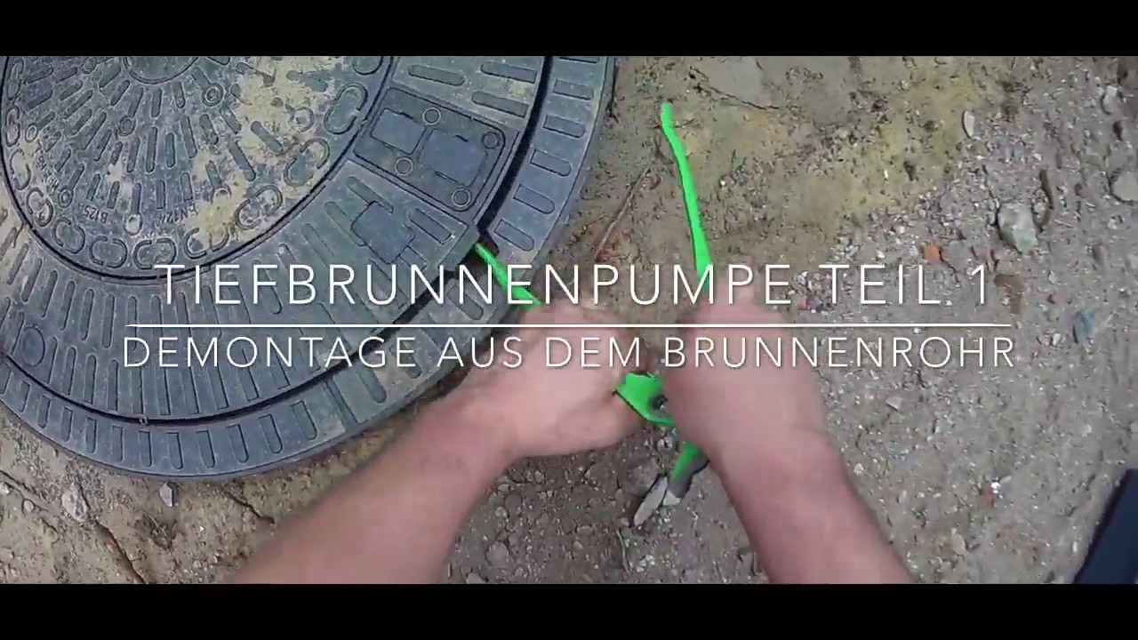Tiefbrunnenpumpe wird aus dem Brunnenrohr demontiert. Brunnen zur Gartenbew&auml;sserung. Gartenbrunnen