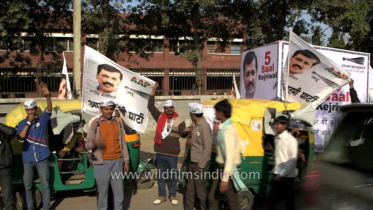 AAP supporters with brooms shout slogans at political rally in Delhi