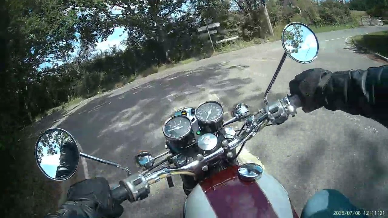 Riding a 1972 Triumph T100R 500 Daytona down a country lane on a summer's day in England.