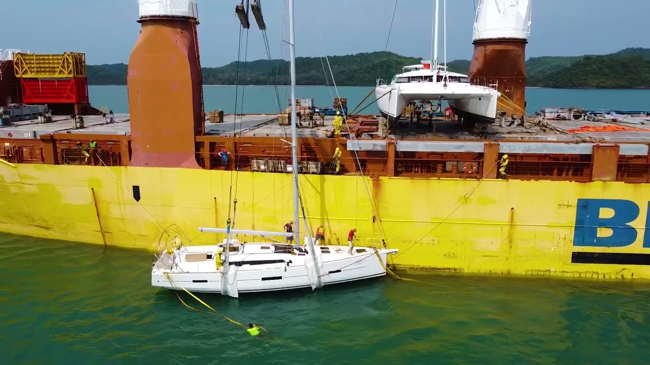 Loading sailboats on board an international cargo ship for shipment abroad