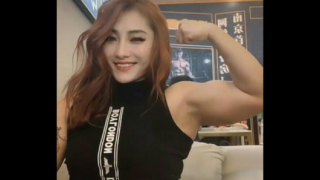 Beautiful muscle girl flexing her biceps 2