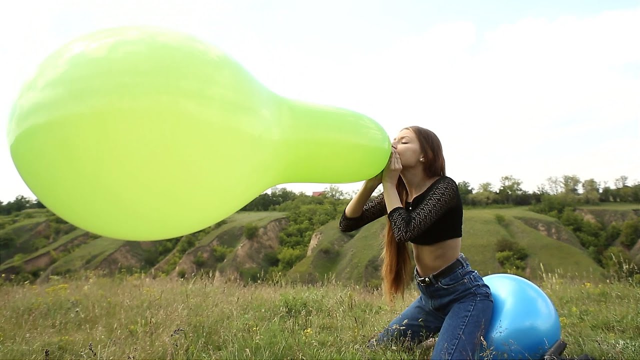 Blowing to pop a huge long balloon