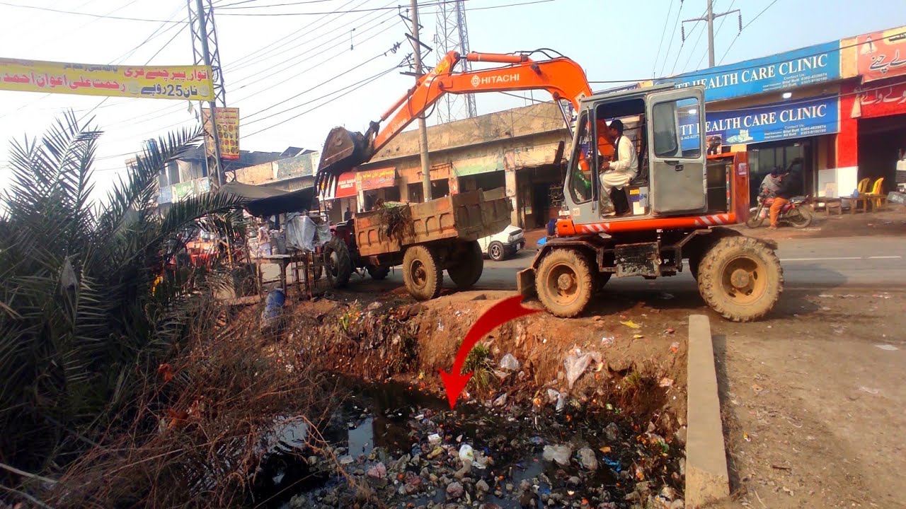Excavator operator loading tractor trolley 
