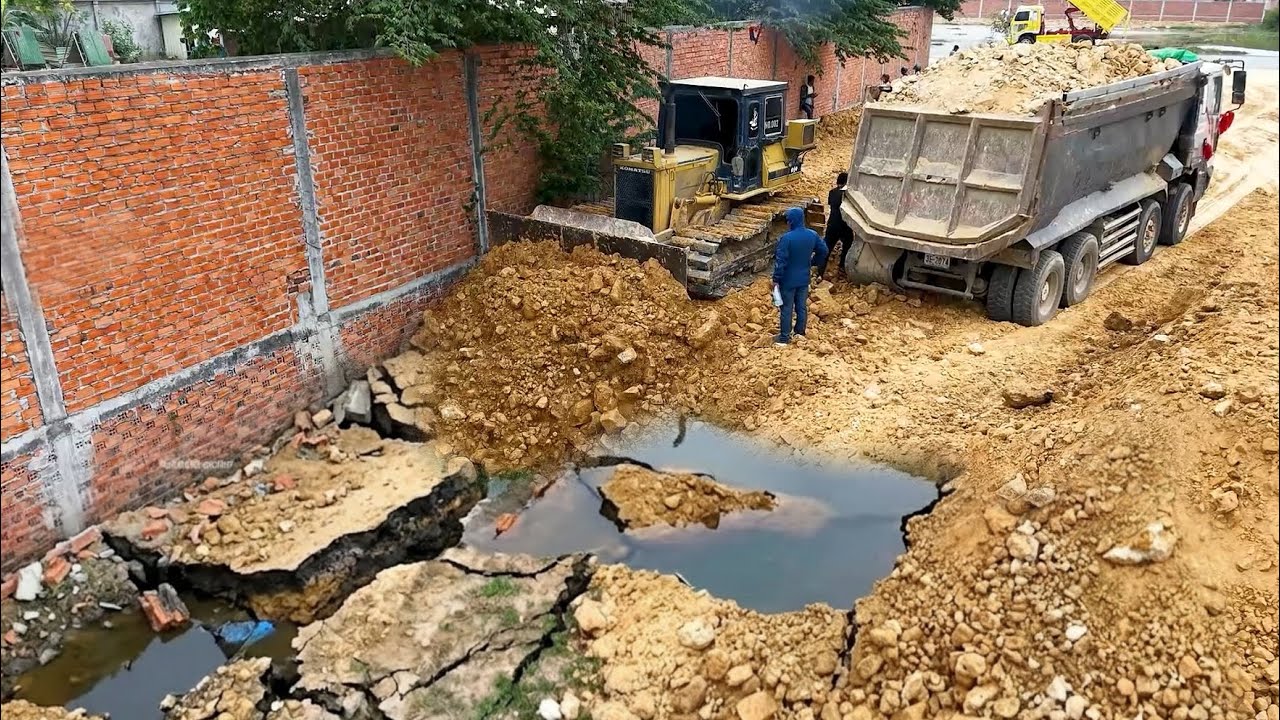 Great work landfill flooded area by Using bulldozer Komatsu D41P working push soil and Dump truck 25