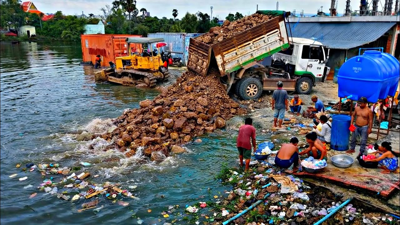 Real scene! A truck dumps dirt and clears a large lake, full of people watching