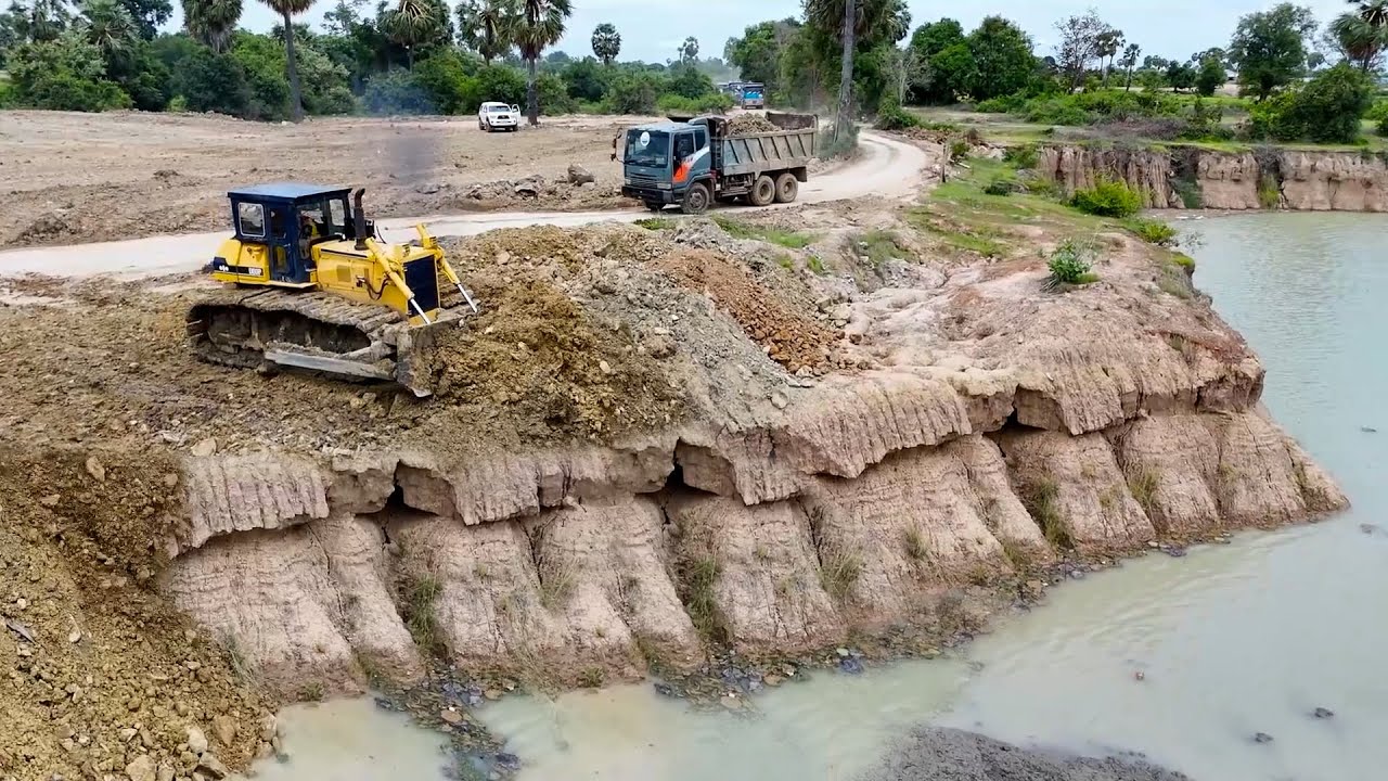 Be Careful When Pouring Soil into Deep Pond with Dump Truck and Bulldozer Push Soil Down into Pond