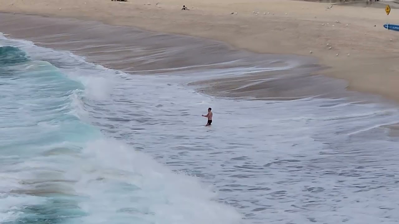 A man playing around with the huge waves at Bronte beach
