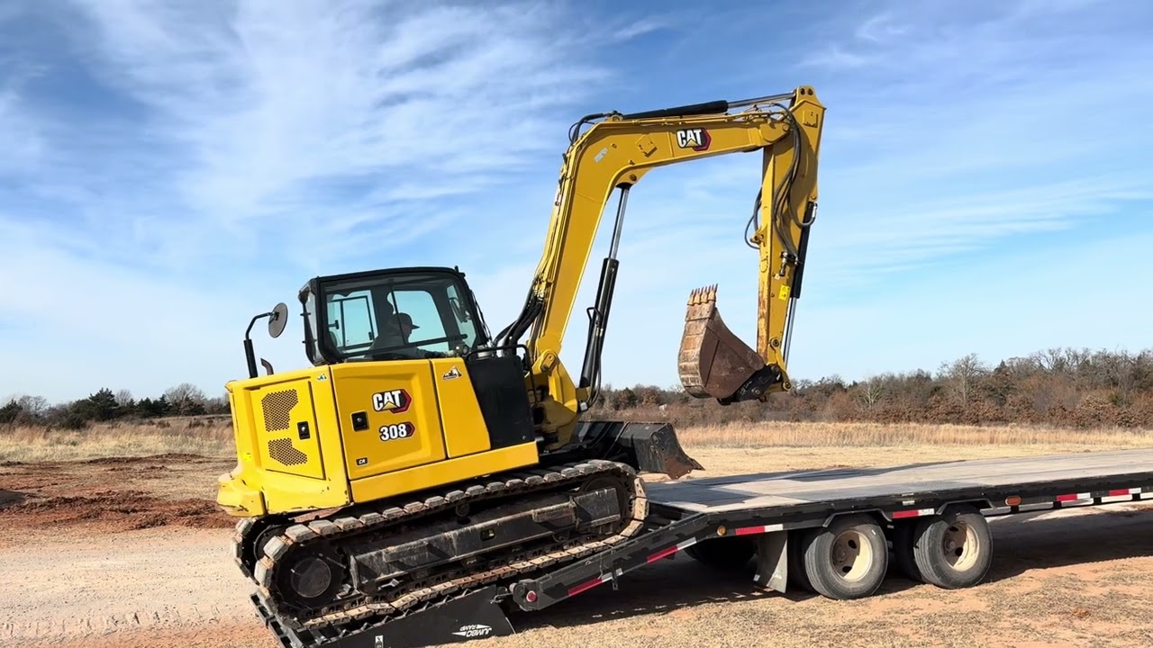 Мини-экскаватор Caterpillar 308 CR продан и загружается в прицеп TopHat с гусиной шеей.