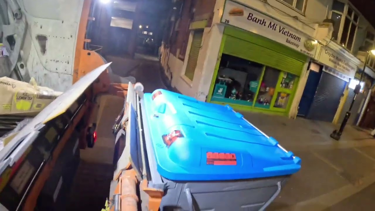 POV ASMR style video in a dustcart/garbage truck collecting waste/garbage recycling in London early