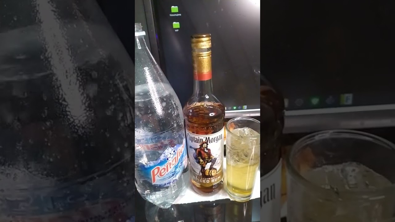 Abriendo una botella de ron especiado pirata morgan con agua mineral de manantial peñafiel riquisimo