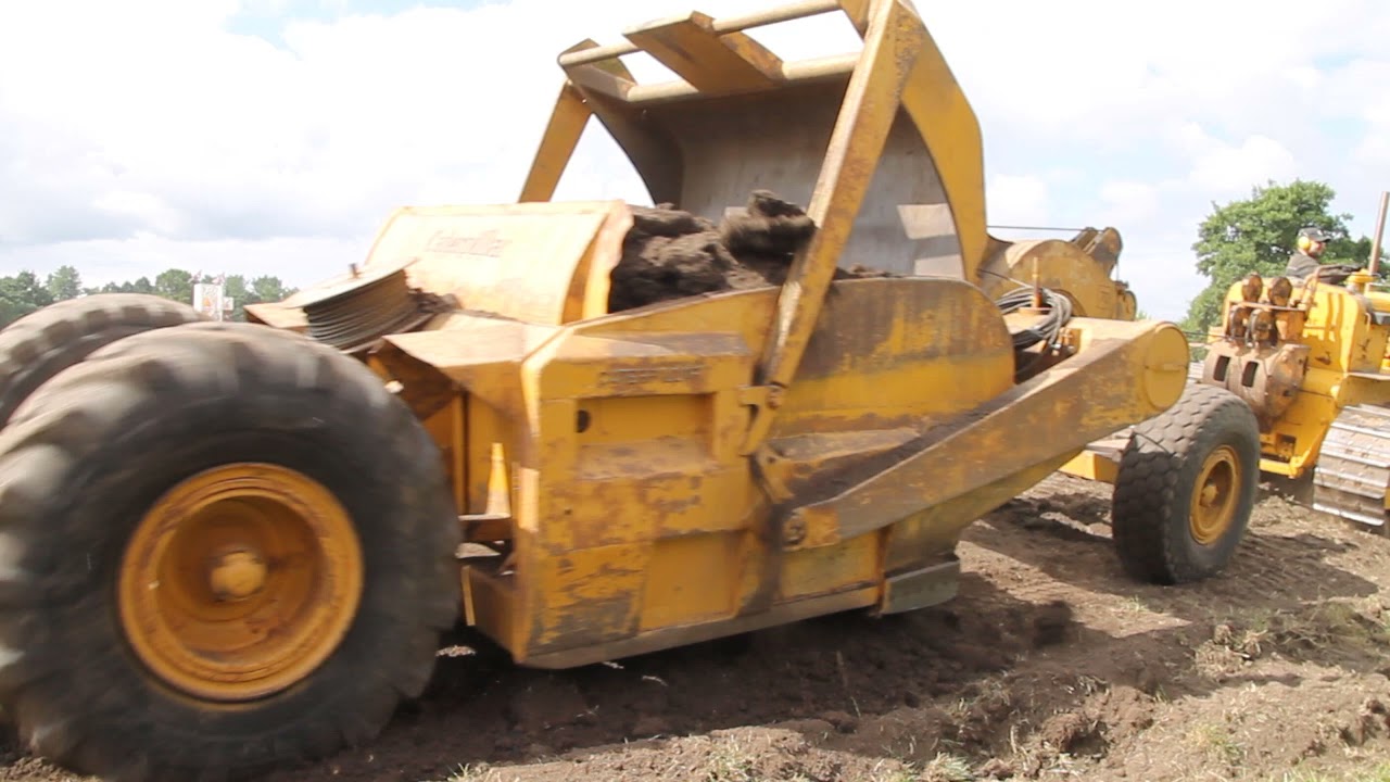 Caterpillar tractors with towed scraper boxes in action