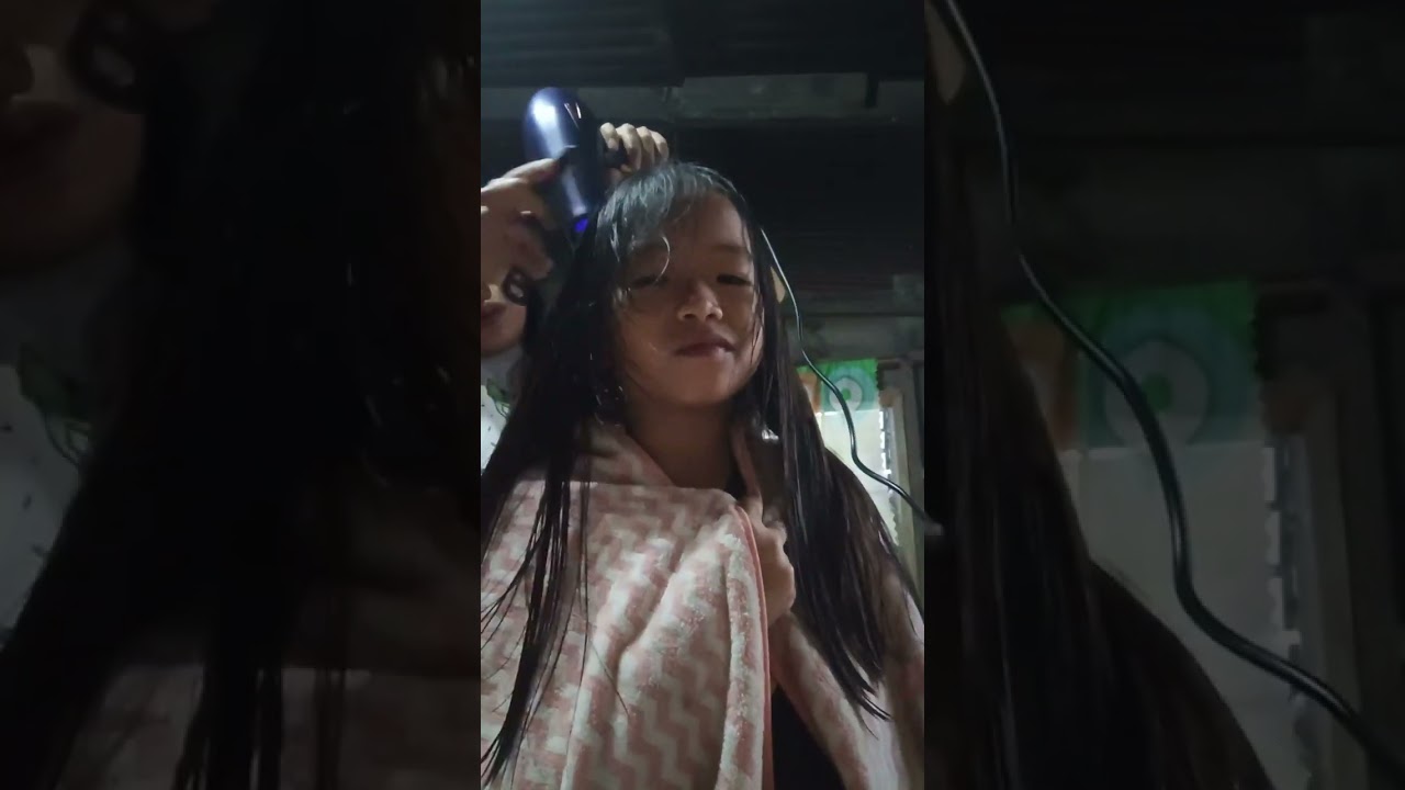Drying her hair using this hair dryer