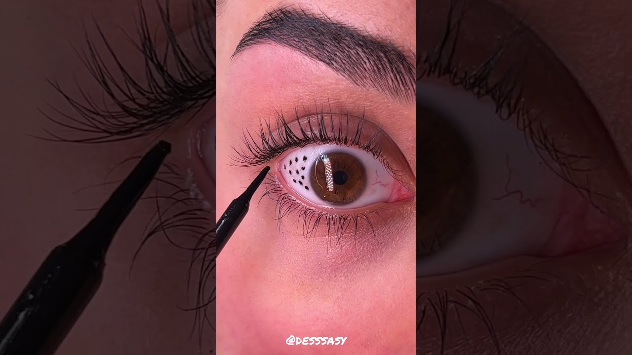 Person uses liquid eyeliner to decorate her eyeball!