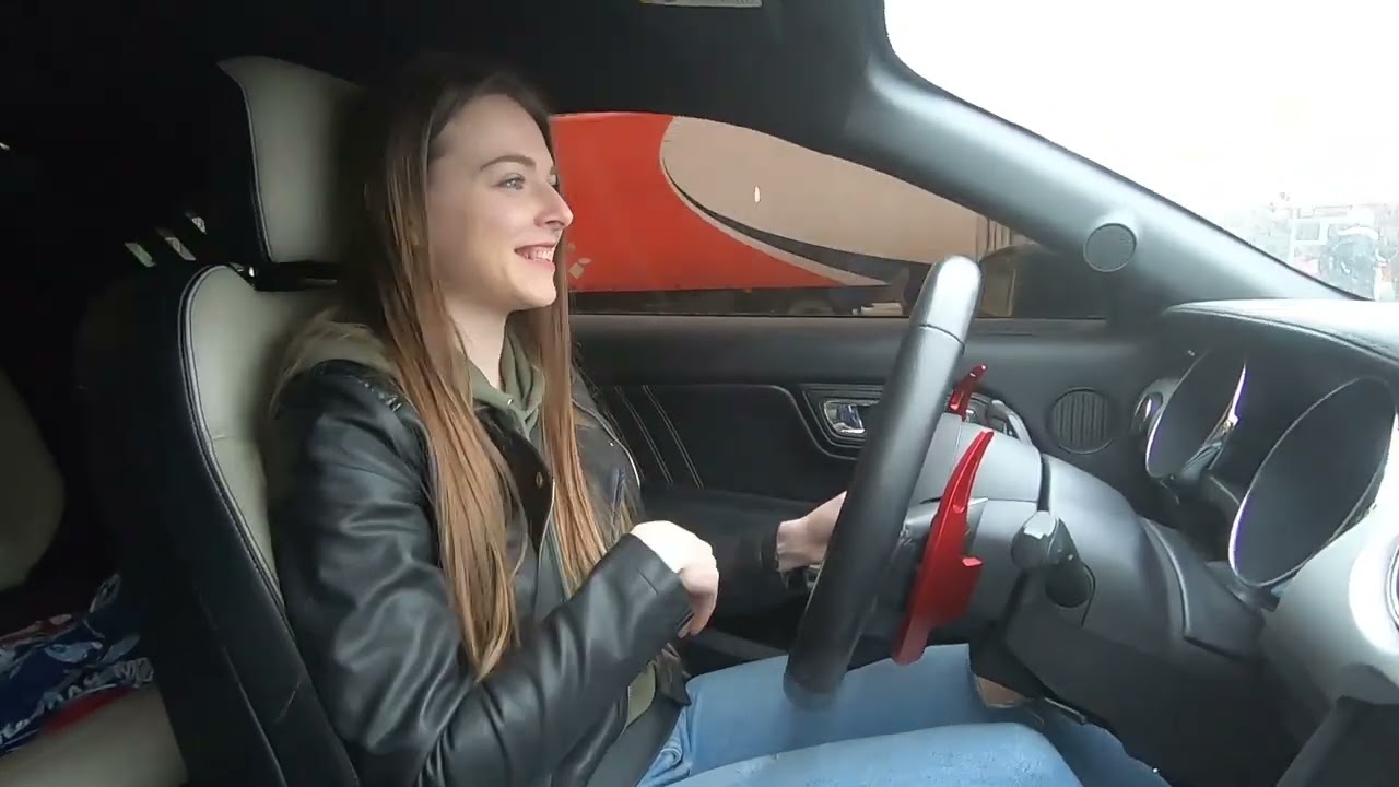 Natasha driving black Mustang