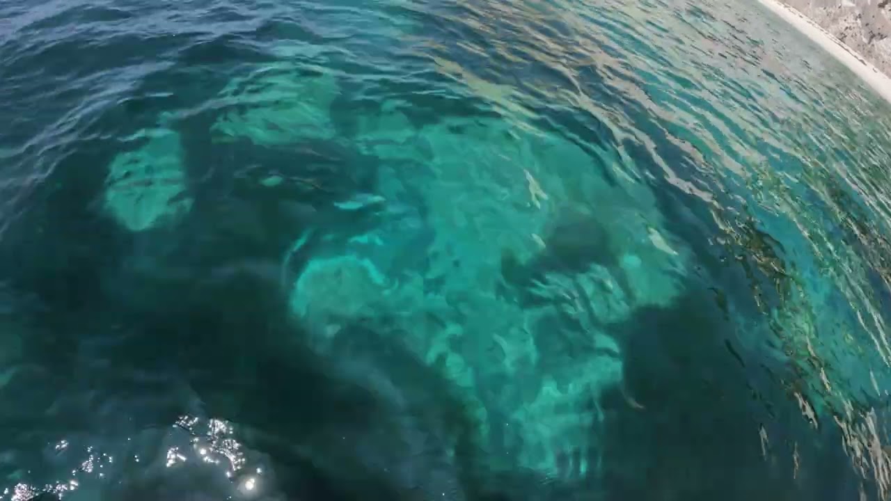 Jumping into crystal blue waters at white rocks beach, Kefalonia - 4K