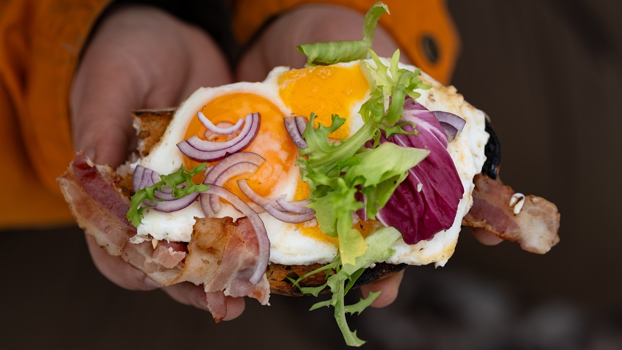 Śniadanie marzeń przygotowane na ognisku. Chrupiący tost z jajkiem, z dodatkiem wędzonego boczku.