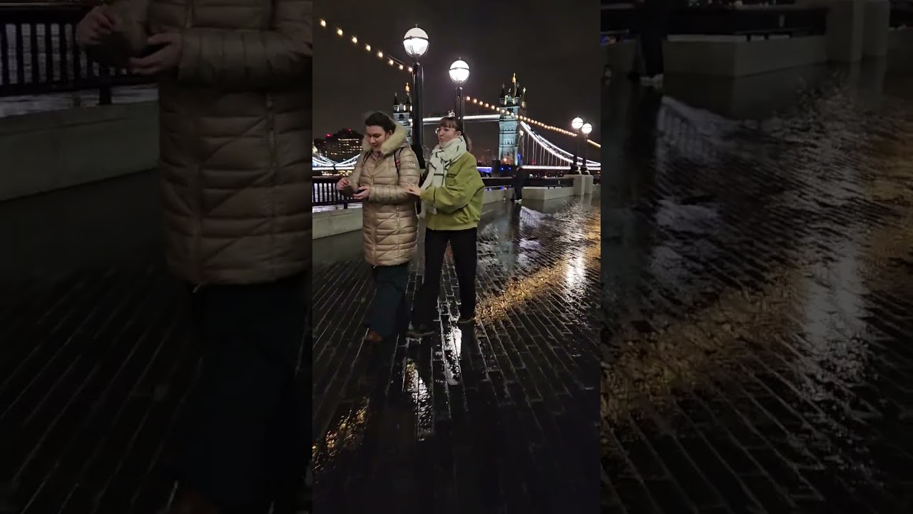Caminhando de London Bridge para Tower of London mostrando as pessoas  na noite chuvosa.