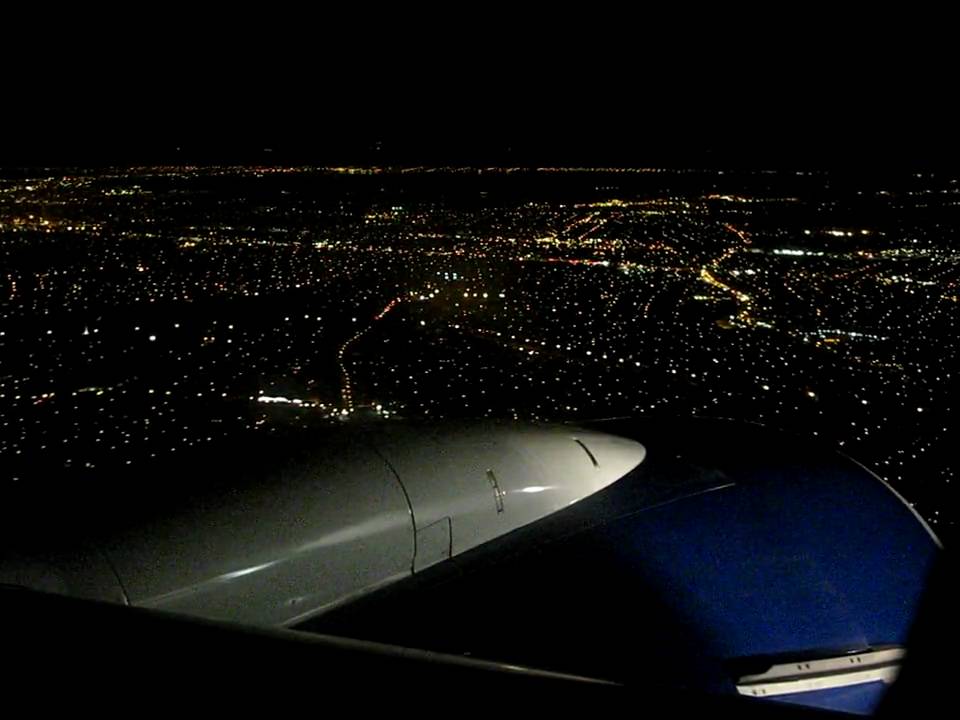 Airplane landing at JFK airport in NY at night.