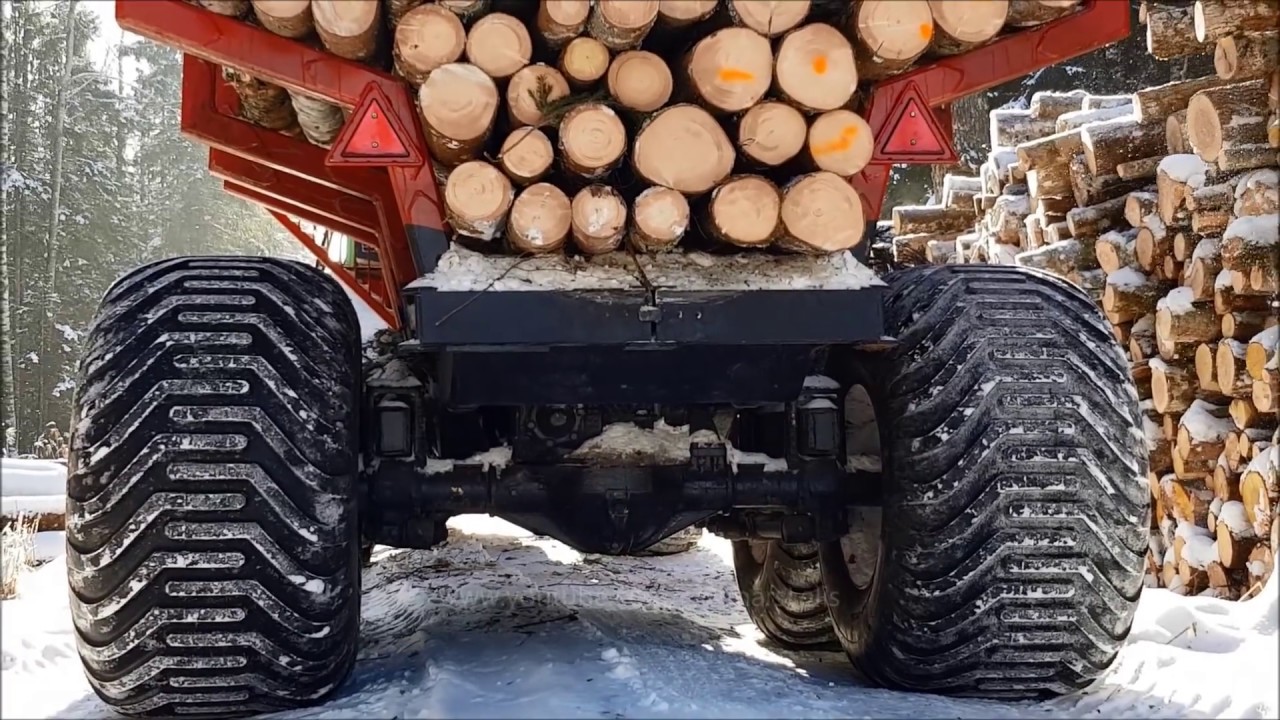MTZ 1025 with homemade 4WD trailer logging in winter forest.