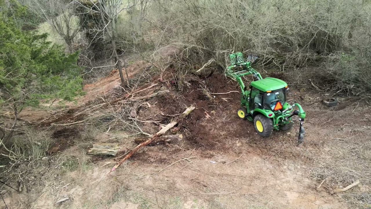 John Deere 3039R Removing Logs with Grapple