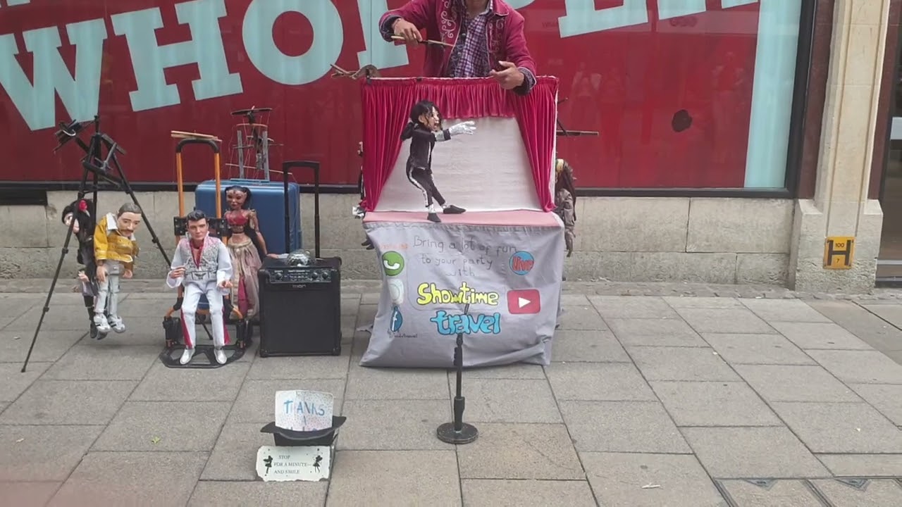Musician outside Burger King with Michael Jackson & Freddie Mercury dolls.