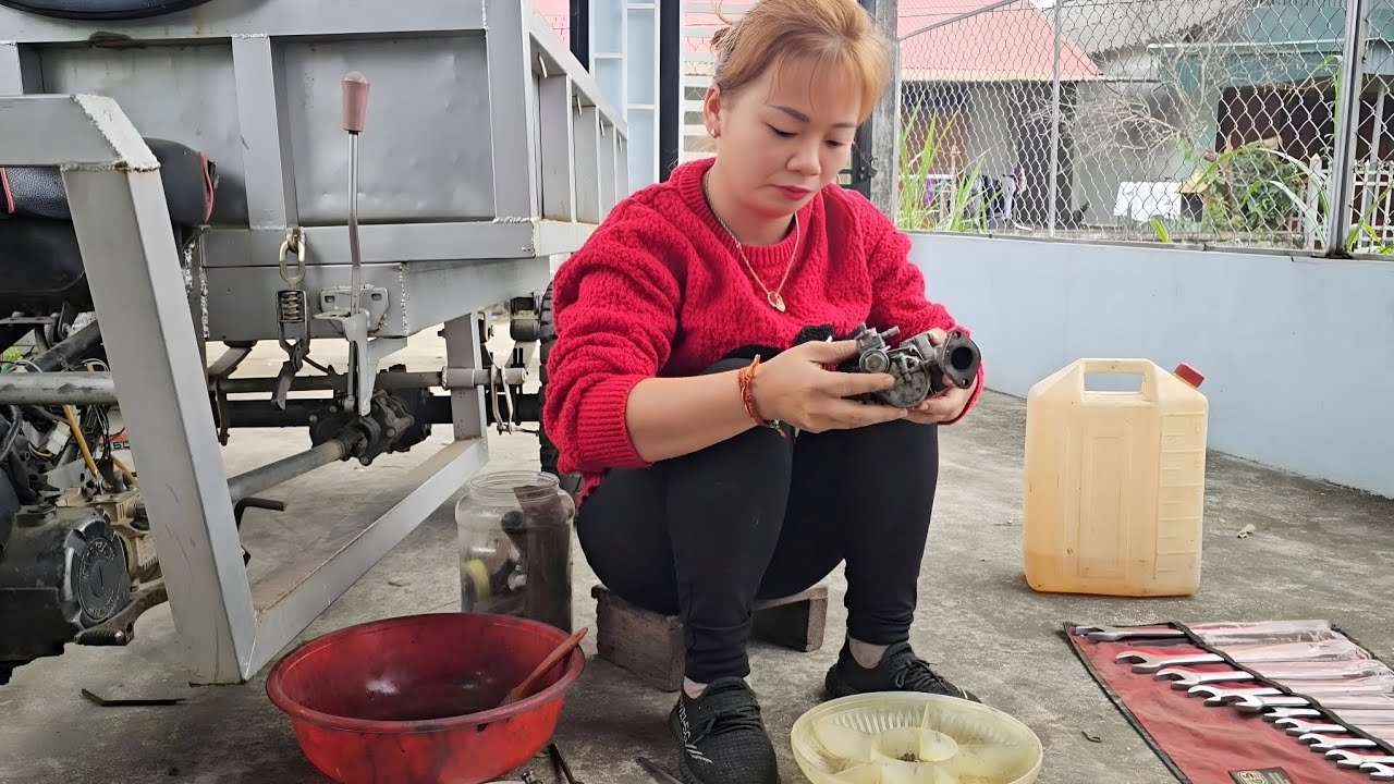 The girl repairs and restores a tricycle for her neighbor.