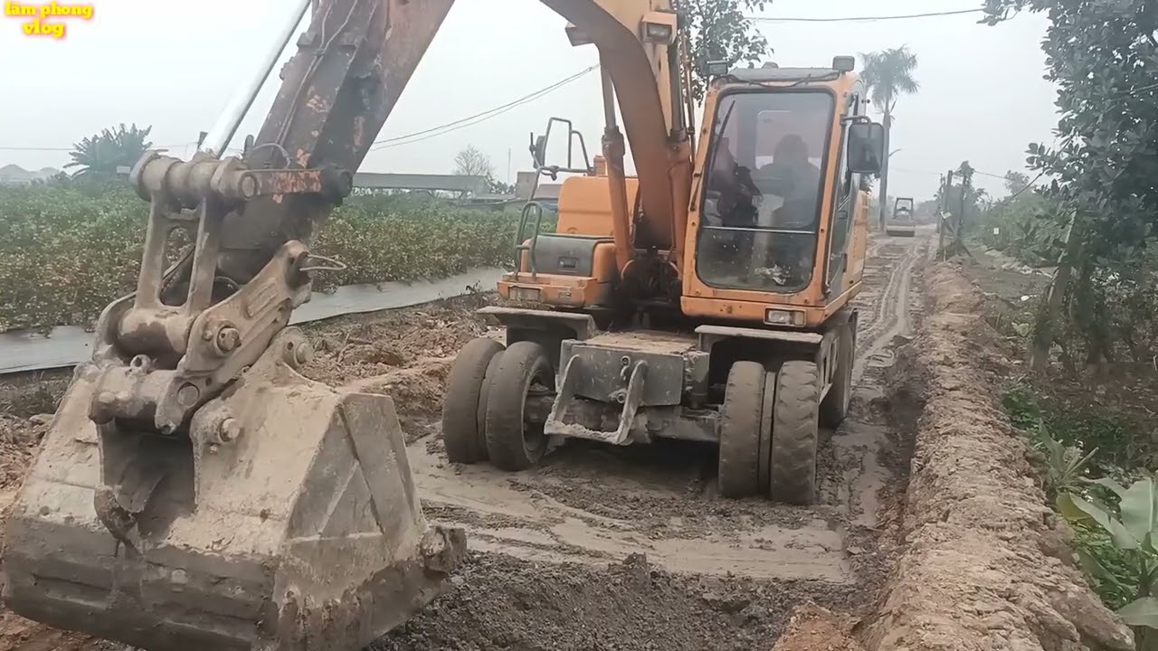 건설 현장에서 굴착기를 조작하는 모습.도로 표면을 평평하게 하세요.굴착기