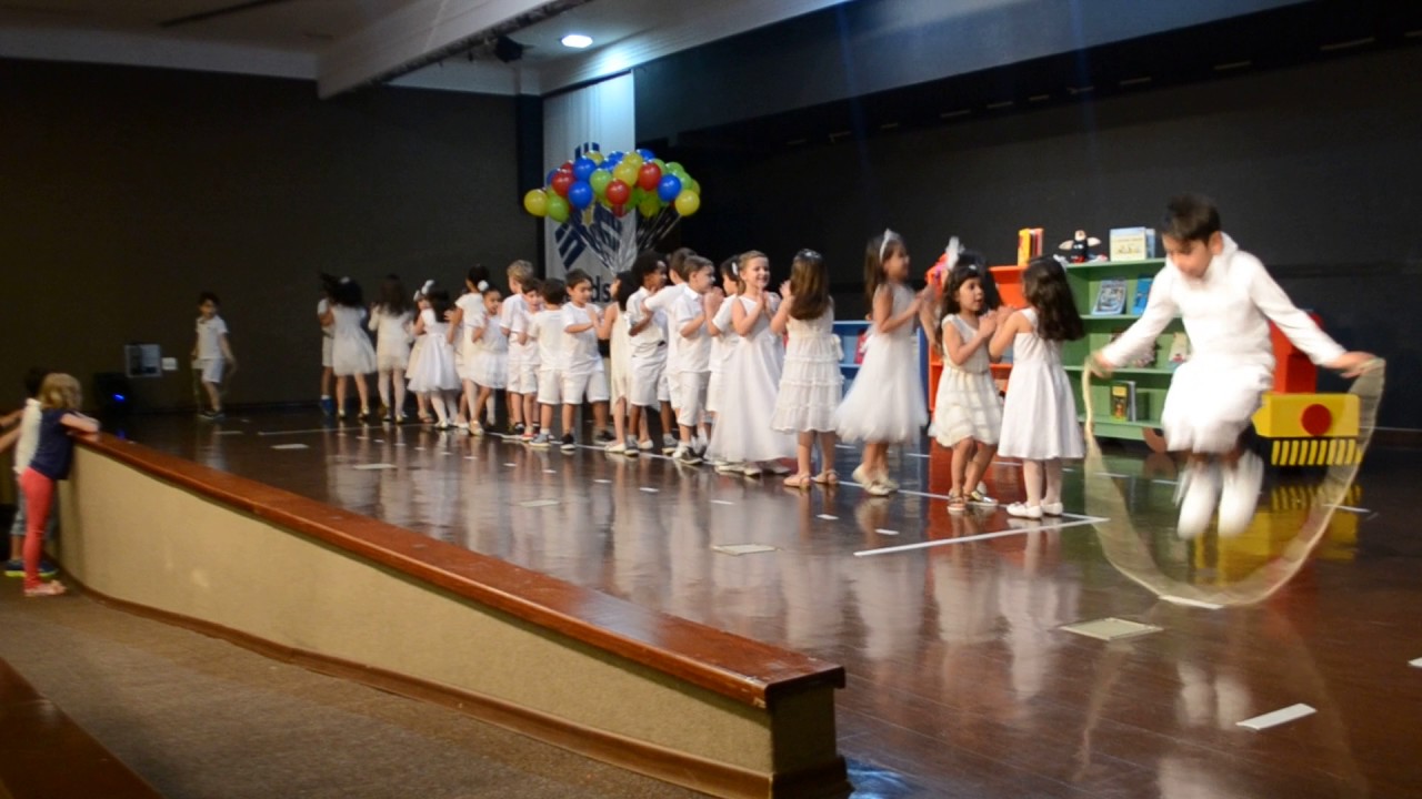 Alunos cantam e dançam a música 