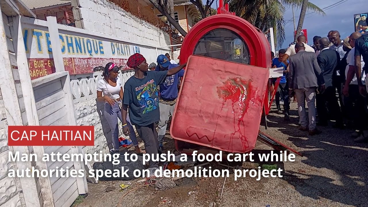 Man attempting to push a food cart while authorities speak on demolition project