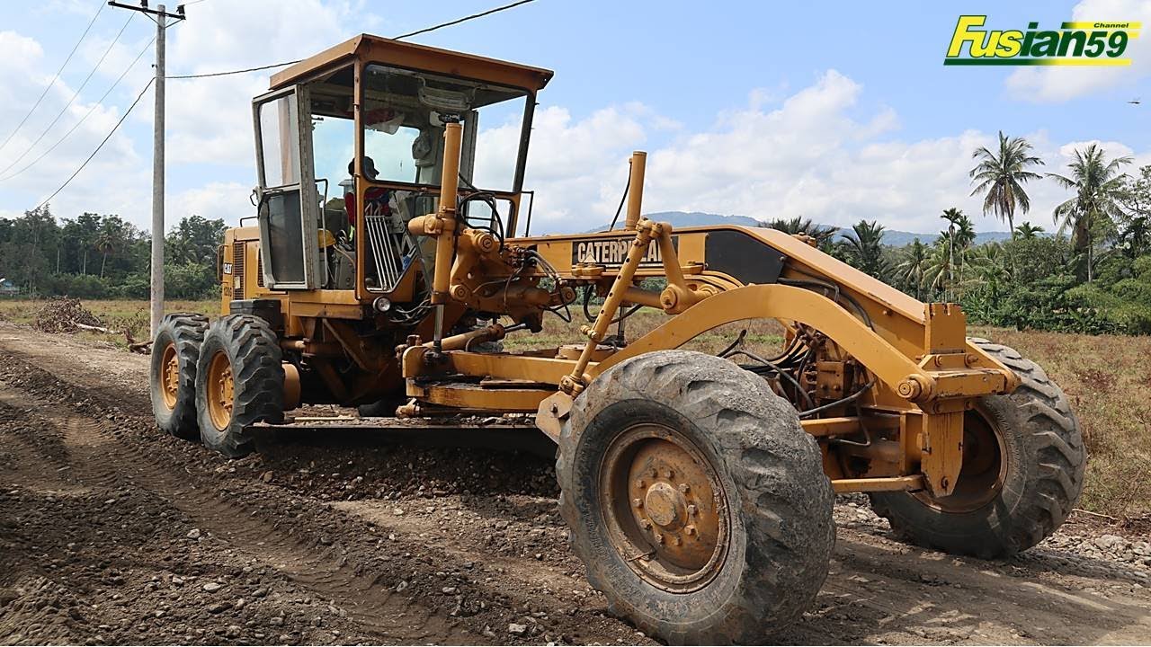 Caterpillar 120G Motor Grader Spreads Road Material