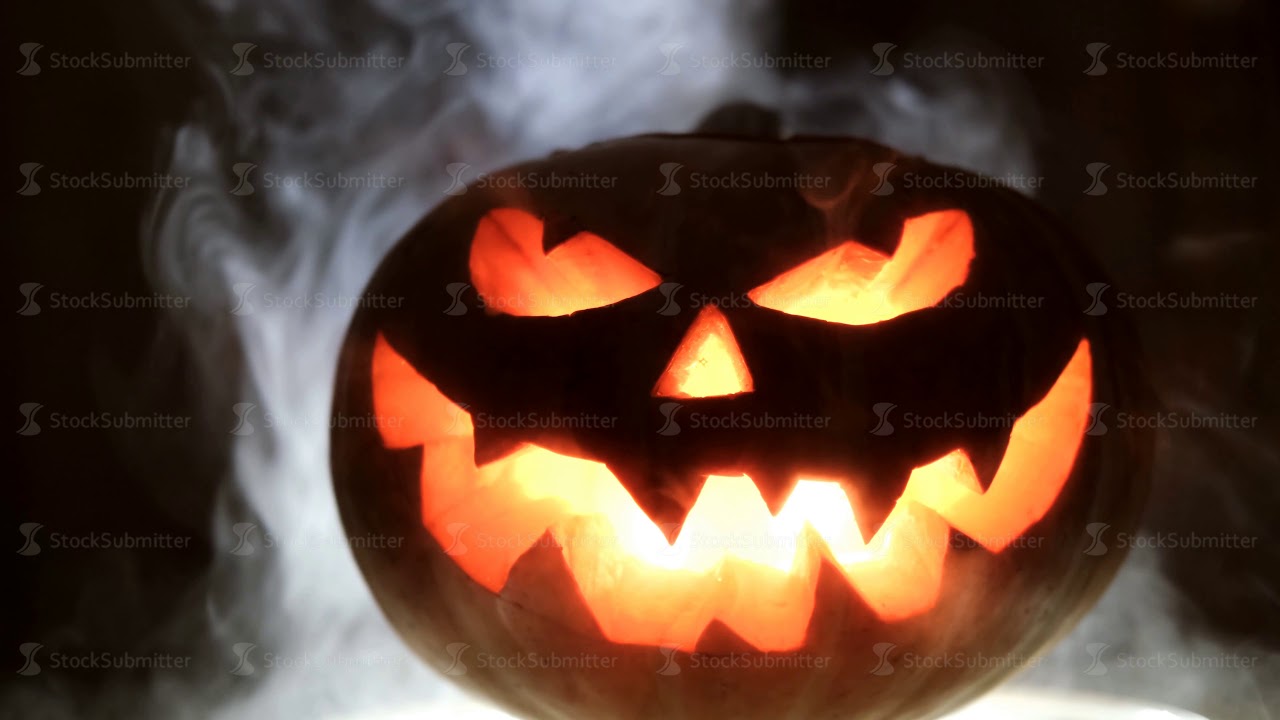 Shining Jack-O-Lantern. Halloween pumpkin with scary face smoke inside with flame.
