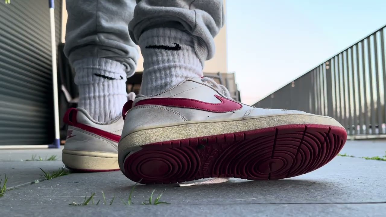 Trashed hot well worn red nike court sneakers shoeplay laces dangling
