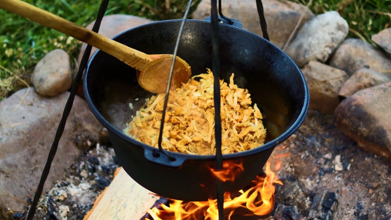 Cooking chanterelle stew with foraged ingredients over an open fire