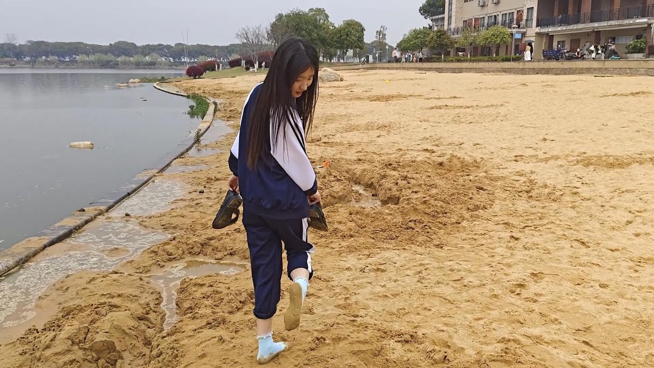 Guli walked along the beach wearing only socks, the soles getting completely covered in sand